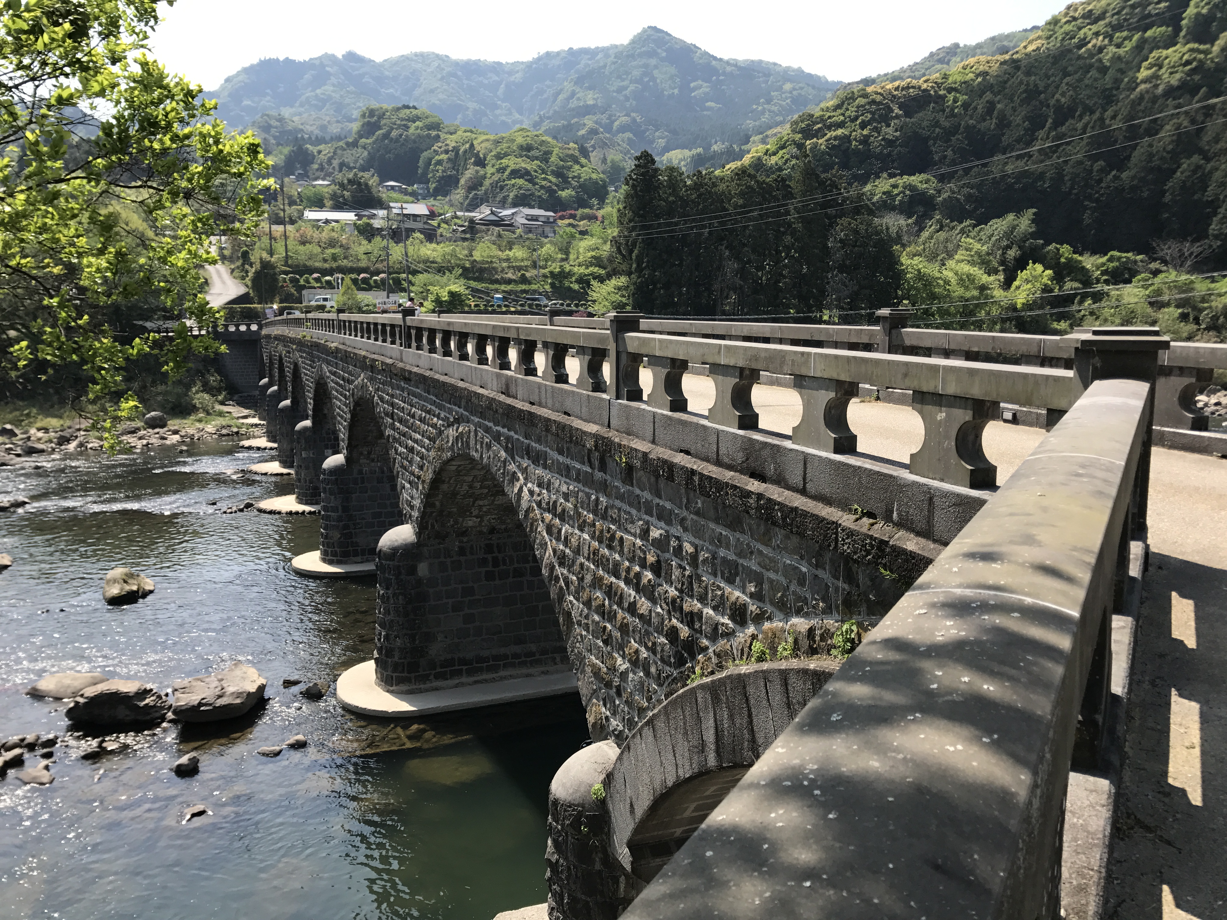 耶馬溪橋的石造拱圈與石欄杆，跨越山國川、背倚青山